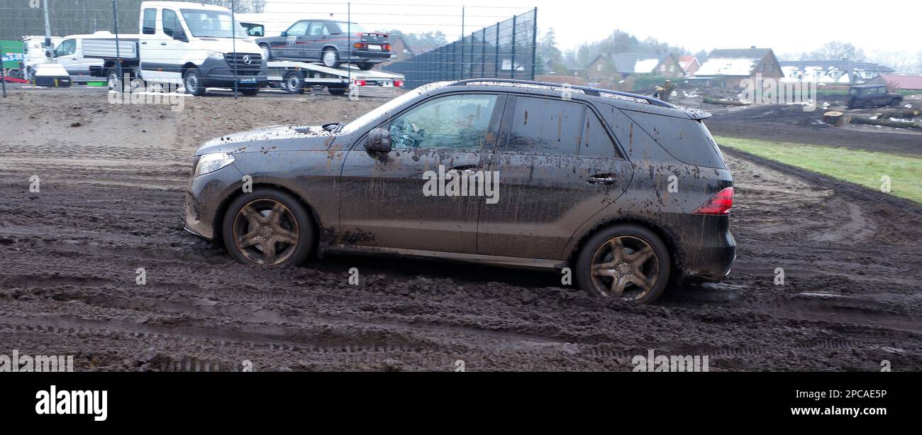 Itterbeck, Germania Marzo 12 2023 Un SUV Mercedes completamente sporco che guida su una pista fuoristrada attraverso il fango. È una Mercedes-Benz W 166 Foto Stock