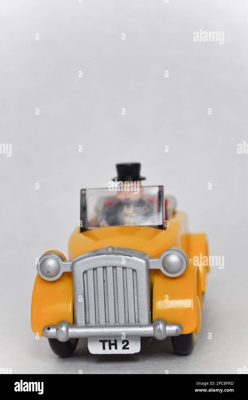Sir Topham Hatt (The Fat Controller) che guida un'auto di plastica gialla della serie Thomas The Tank Engine Foto Stock