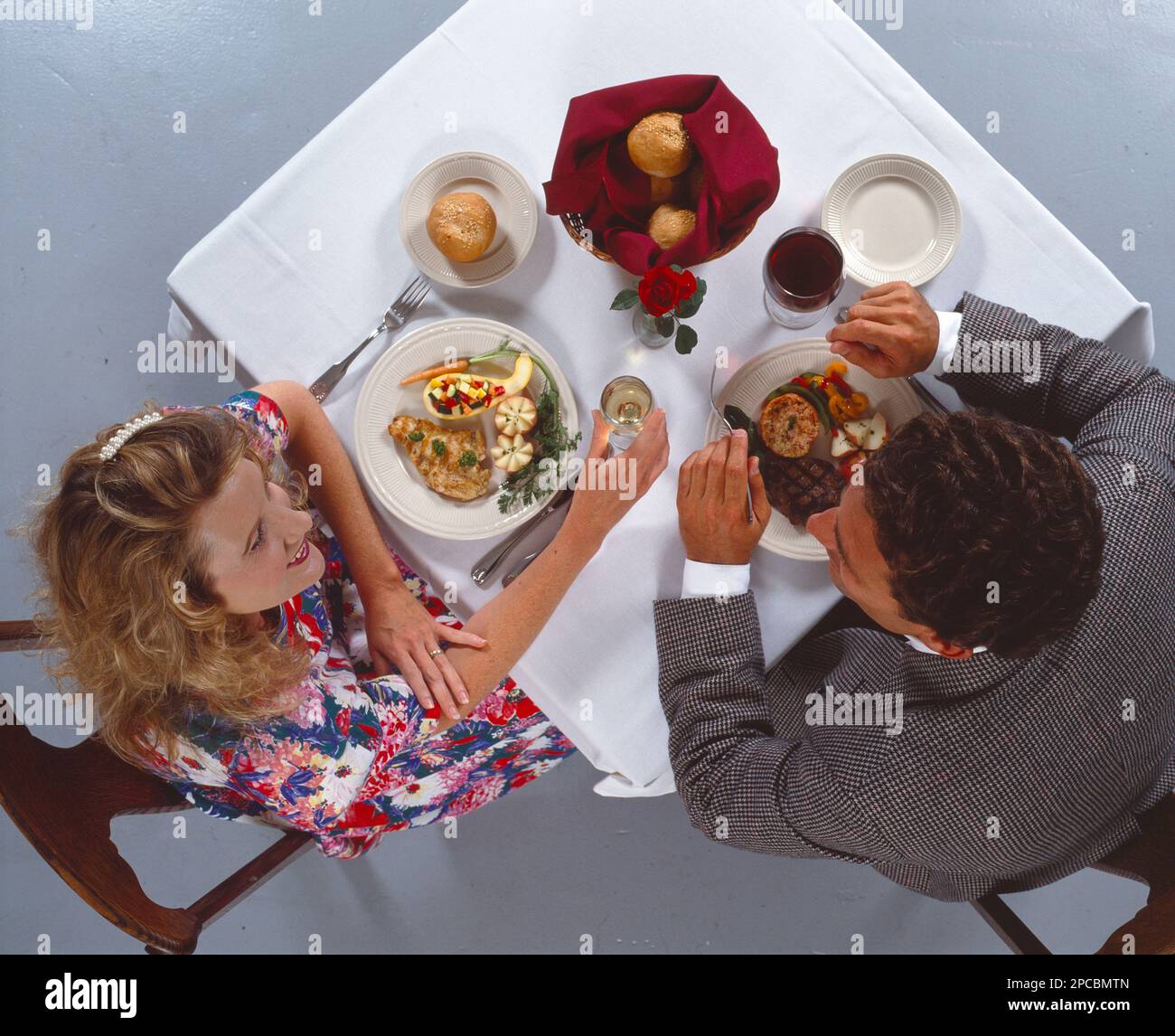 La vista dall'alto guardava verso il basso di una coppia giovane ben vestita e di una bella sala da pranzo Foto Stock