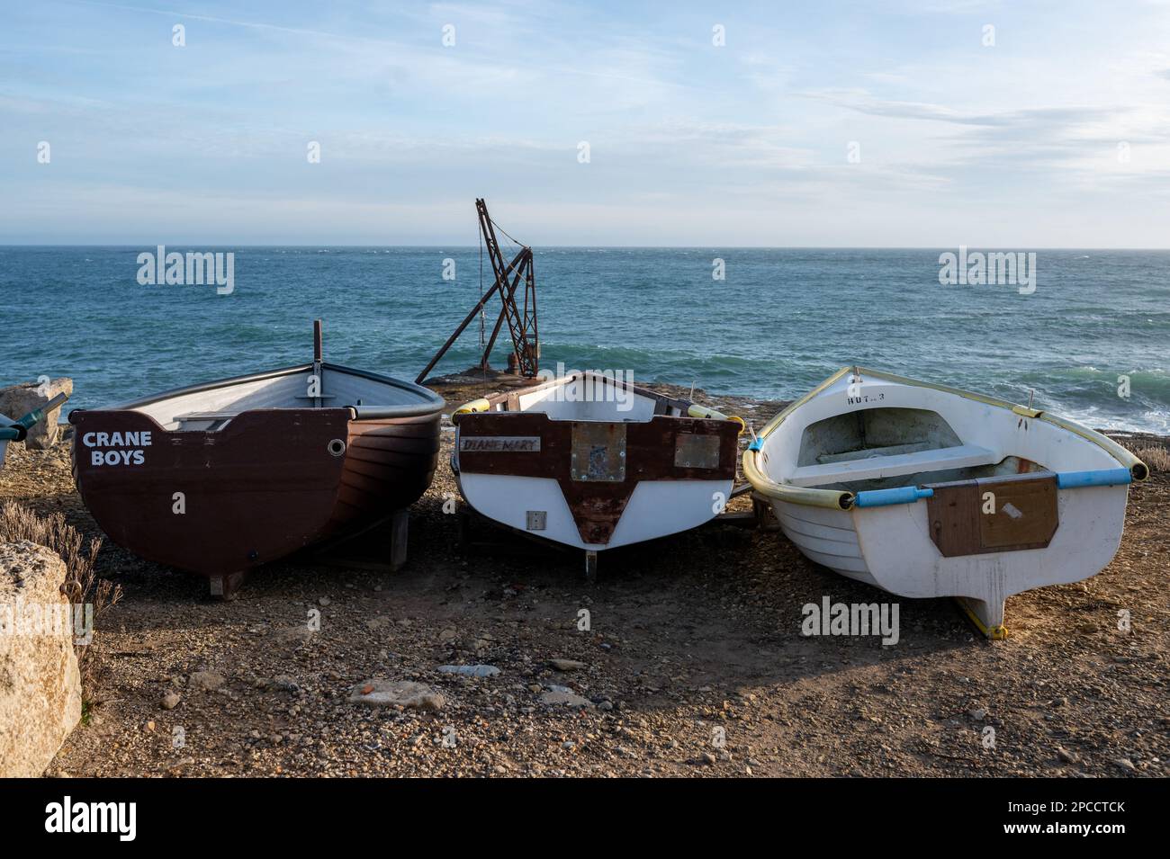 Tre piccole barche vicino alla gru a Portland Bill in Dorset. Foto Stock