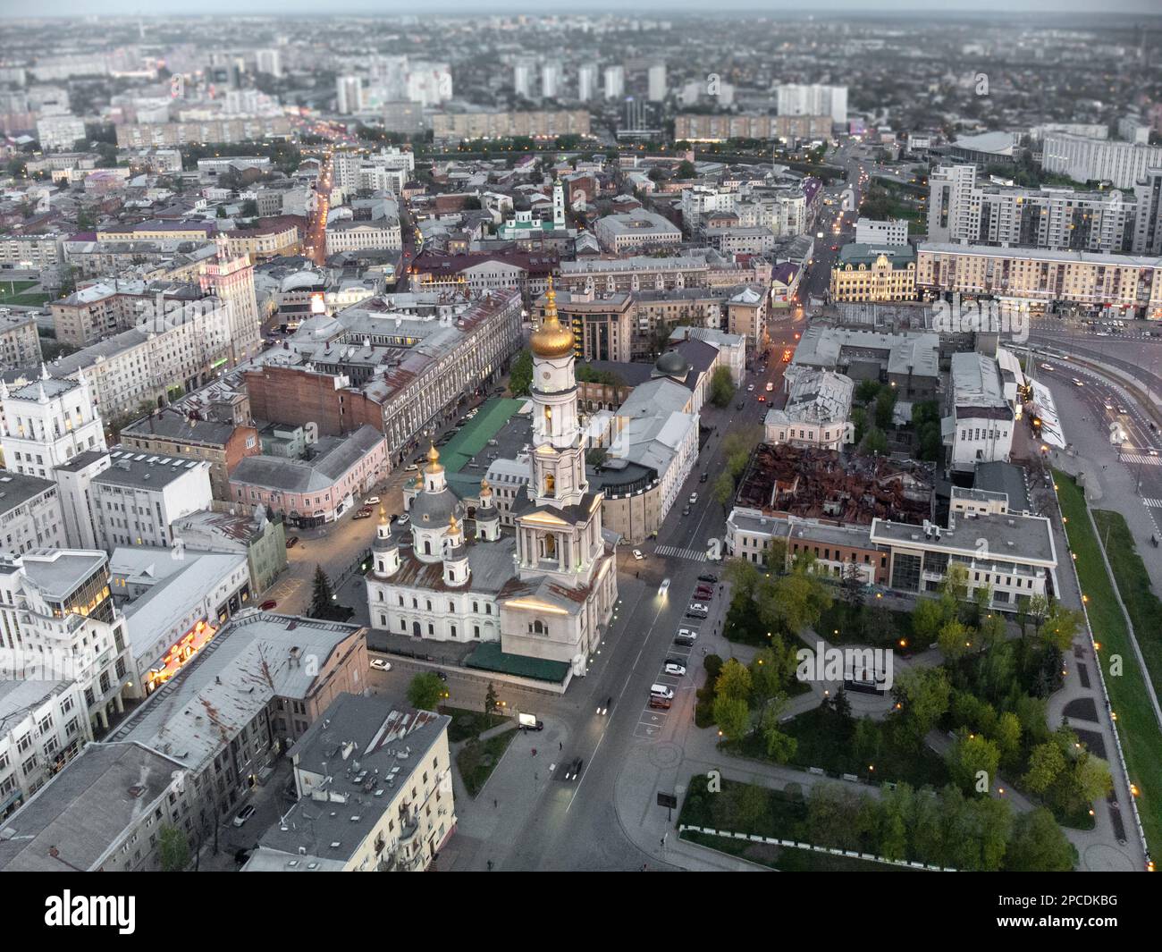 Veduta aerea della Cattedrale della Dormizione con cupola dorata e strade alle luci serali del centro cittadino di Kharkiv, Ucraina. Messa a fuoco selettiva con sfocatura Foto Stock