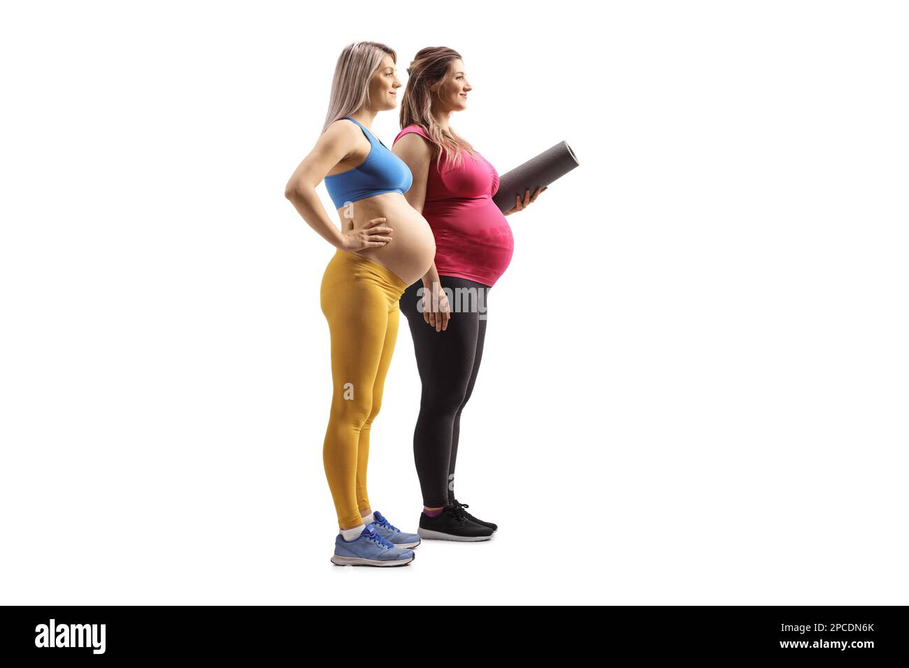 Foto a profilo completo di due donne in gravidanza che indossano abbigliamento sportivo isolato su sfondo bianco Foto Stock