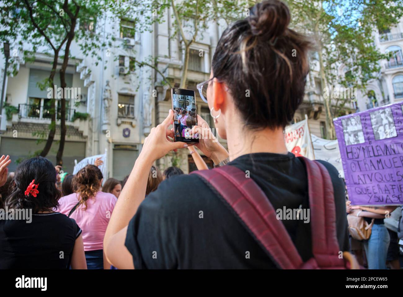 Buenos Aires, Argentina; 8 marzo 2023: Sciopero femminista internazionale. Donna che scatta foto e video mentre gruppi di donne marciano e cantano slogan Foto Stock