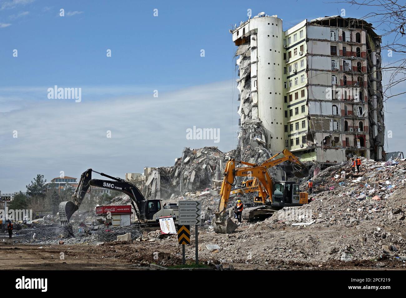 I macchinari da costruzione eliminano i detriti mentre il quarto blocco danneggiato del complesso Galeria attende la demolizione. Tonnellate di detriti pesanti del sito di Galeria, dove uno dei 4 blocchi è crollato e ha ucciso 89 persone nella città di Diyarbakir durante i gravi terremoti che si sono verificati il 6 febbraio in Turchia, è in corso di pulizia. Inizialmente, il ferro e altri residui metallici vengono separati dal calcestruzzo e inviati per il riciclaggio. Il sito si compone di 12 piani e 4 blocchi. Sono stati demoliti sotto controllo anche i 4 piani inferiori del centro commerciale e i due e terzi blocchi del sito gravemente danneggiato, Foto Stock