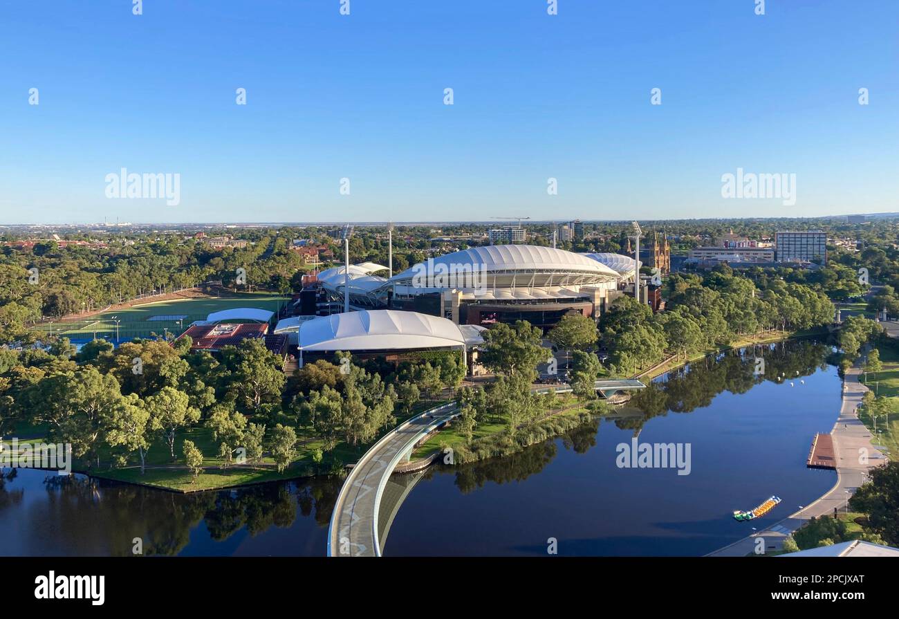 Vista aerea del campo da cricket e del centro tennis di Adelaide Oval, con il ponte pedonale dalla città e il CBD che attraversa il fiume Torrens Foto Stock