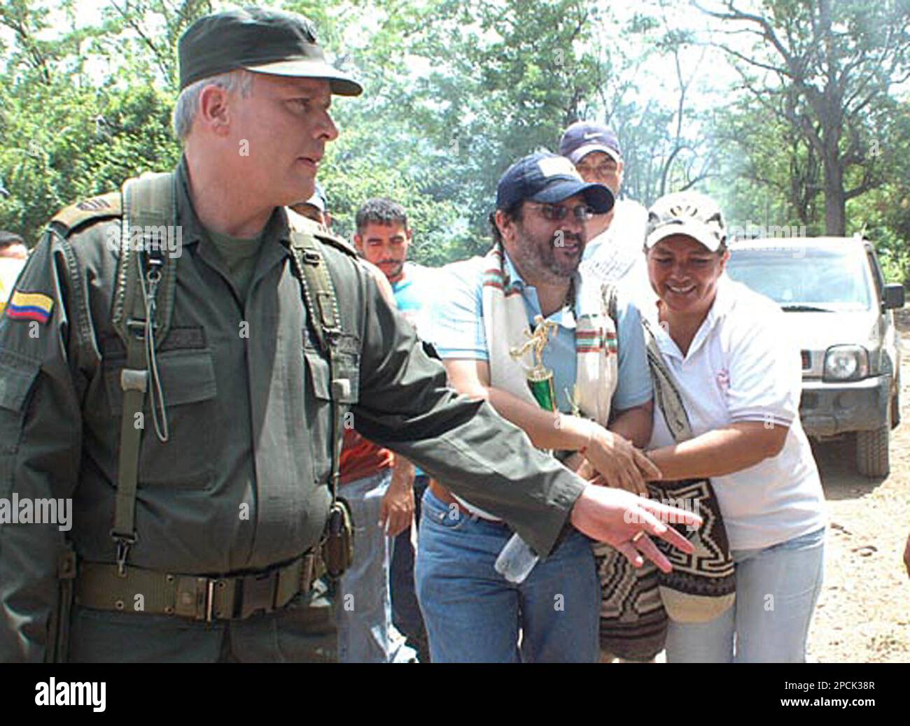 Paramilitary leader Rodrigo Tovar, alias "Jorge 40" , center, is embraced by a woman after he arrives to turn himself over to authorities at a police station in Valledupar, 410 miles, northeast of Bogota, Monday, Sept. 4, 2006. Tovar, who is accused of perpetrating a number of massacres against civilians as well as being a major drug-trafficker, reigned over much of Colombia's Caribbean coast, deciding who could and could not run for public office. (AP Photo/Emilio Castrillon, El Pilon) Foto Stock