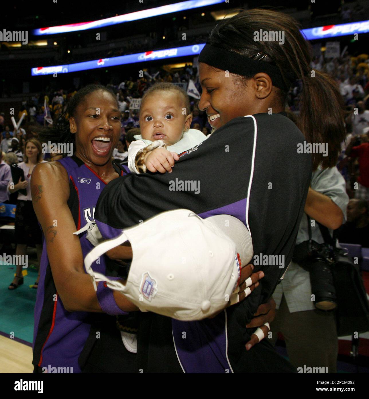 Sacramento Monarchs' Yolanda Griffith, left, celebrates with teammate DeMya Walker, right, and Walker's 4-month-old daughter, Tachara, center, after the Monarchs won the WNBA Western Conference championship with a 72-58 win in game 2 over the Los Angeles Sparks on Saturday, Aug. 26, 2006, in Anaheim, Calif. (AP Photo/Danny Moloshok) Foto Stock