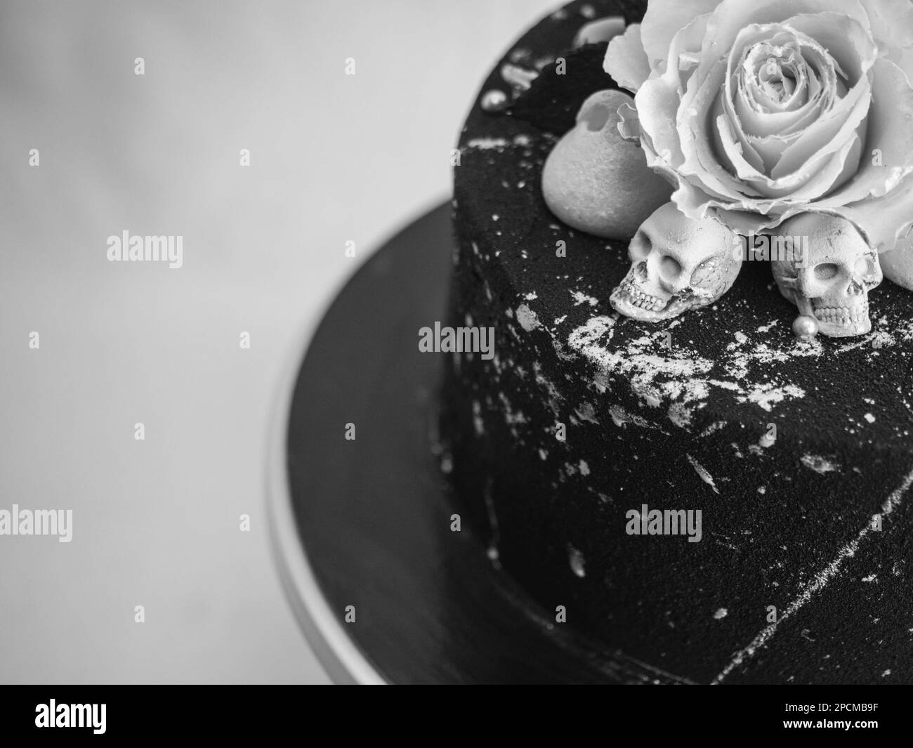 torta glassata con airbrush nero di compleanno dipinta, due vere rose in argento spruzzato e toppa al cioccolato commestibile e pennellate in argento Foto Stock