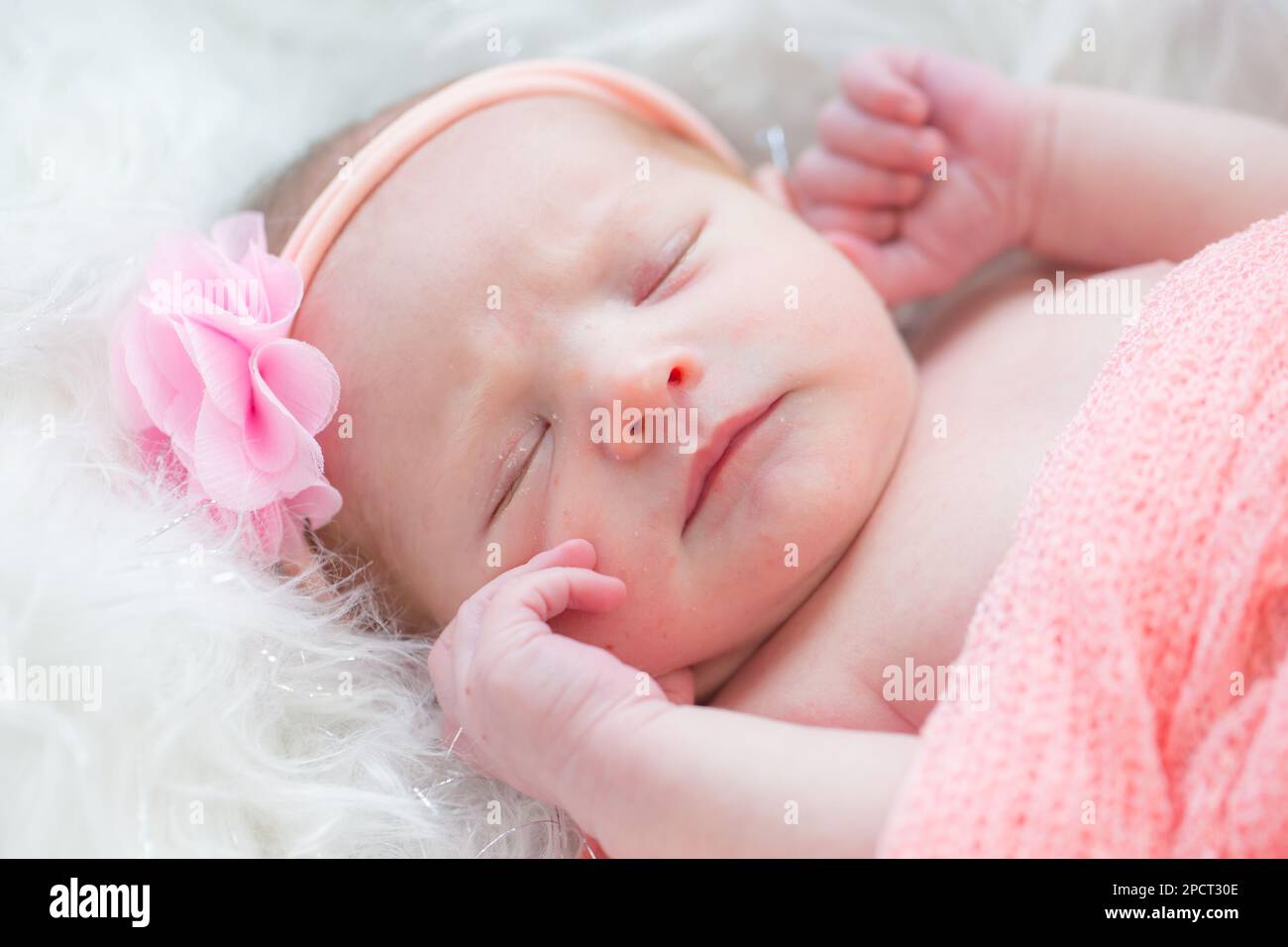 Primo piano di una bella bambina neonato che indossa una fascia in tessuto . Foto Stock