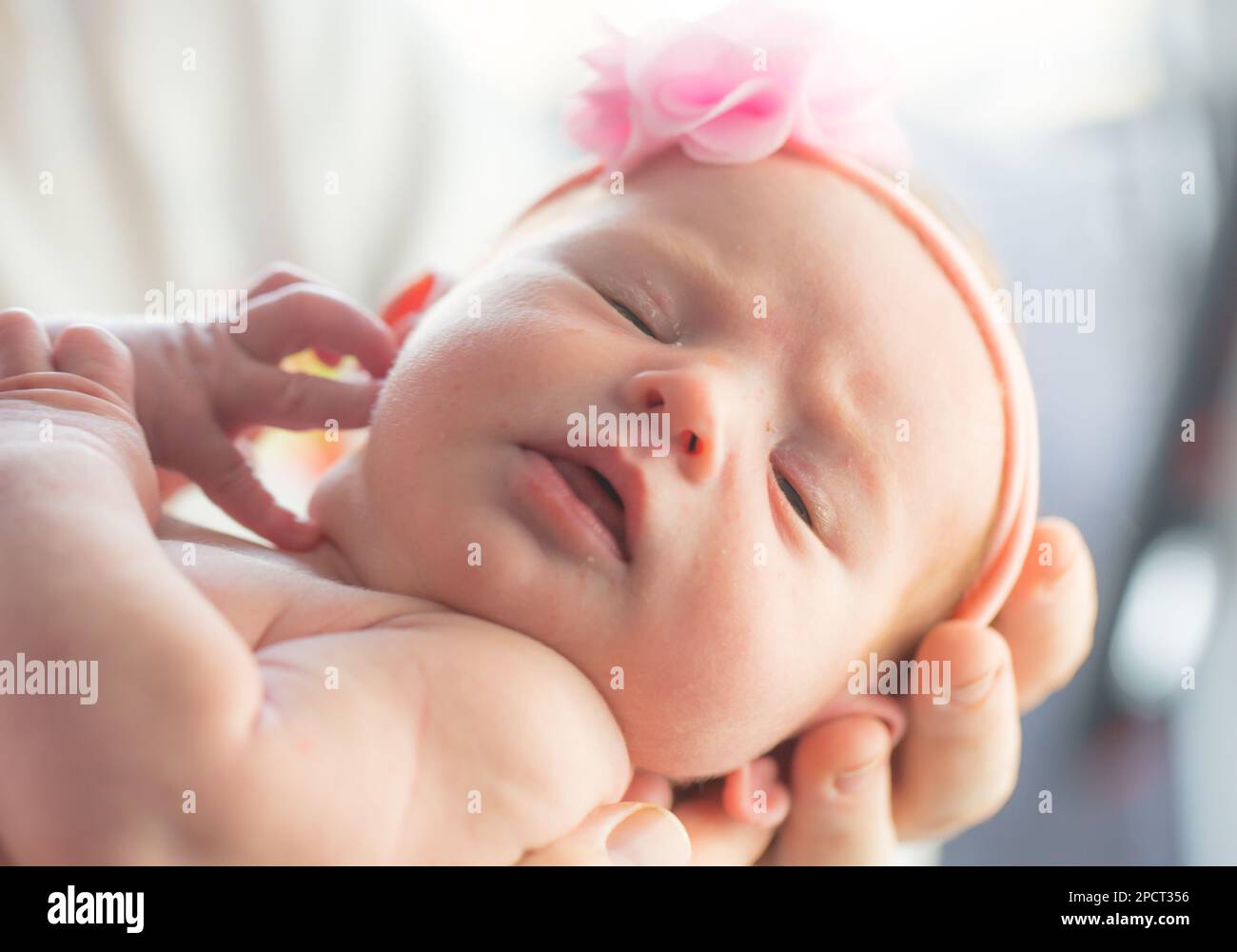 Primo piano di una bella bambina neonato tenuta dai suoi genitori. Foto Stock