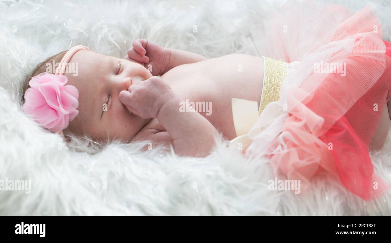 Primo piano di una bella bambina neonato che indossa una fascia in tessuto. Foto Stock