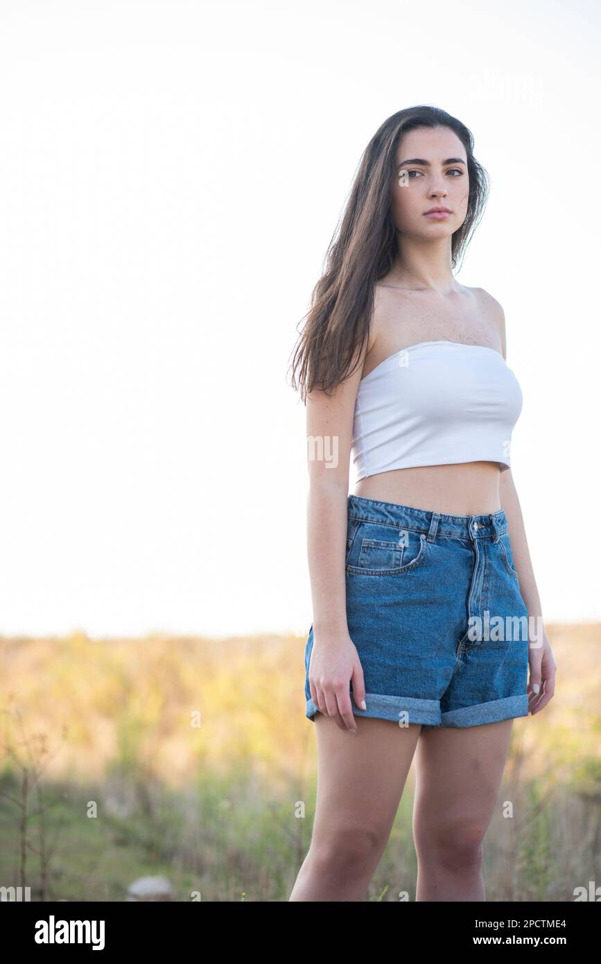 Bella giovane donna in jeans shorts all'aperto Foto Stock