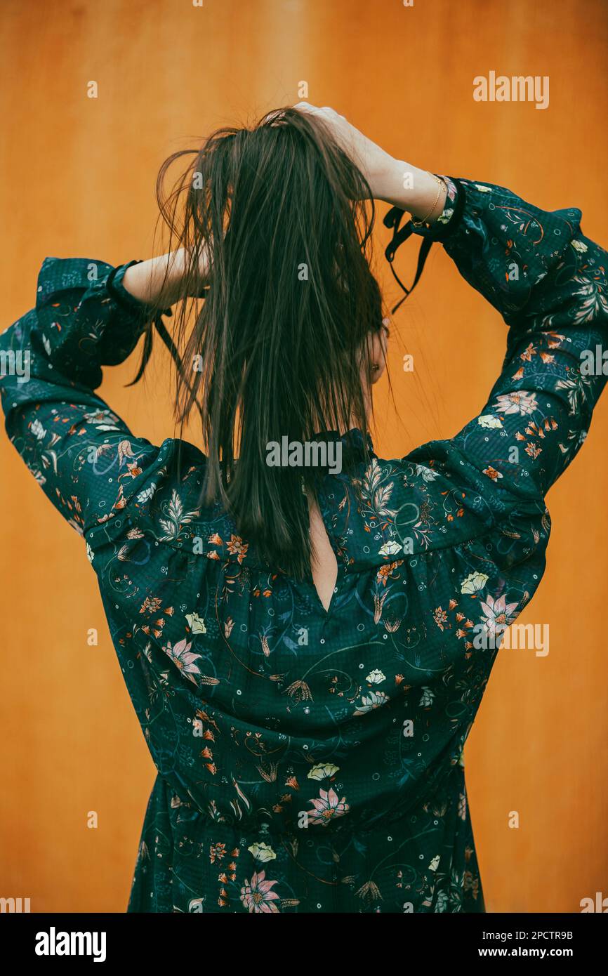 Vista posteriore della donna che tira i capelli verso l'alto Foto Stock