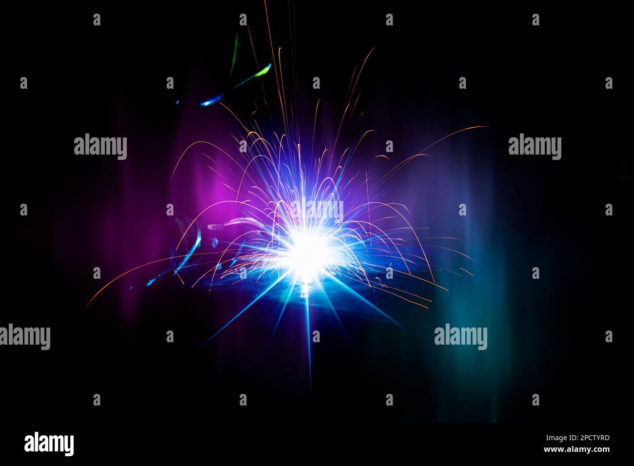 Scintille luminose che volano dalla saldatura su uno sfondo scuro. Foto Stock