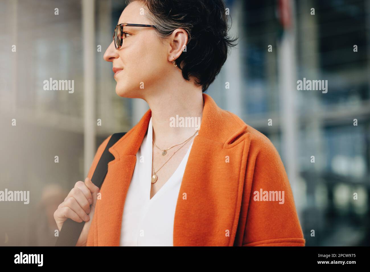 Donna d'affari premurosa che guarda via mentre cammina per lavorare in città. Donna d'affari matura che si collega al suo ufficio a piedi la mattina. Foto Stock
