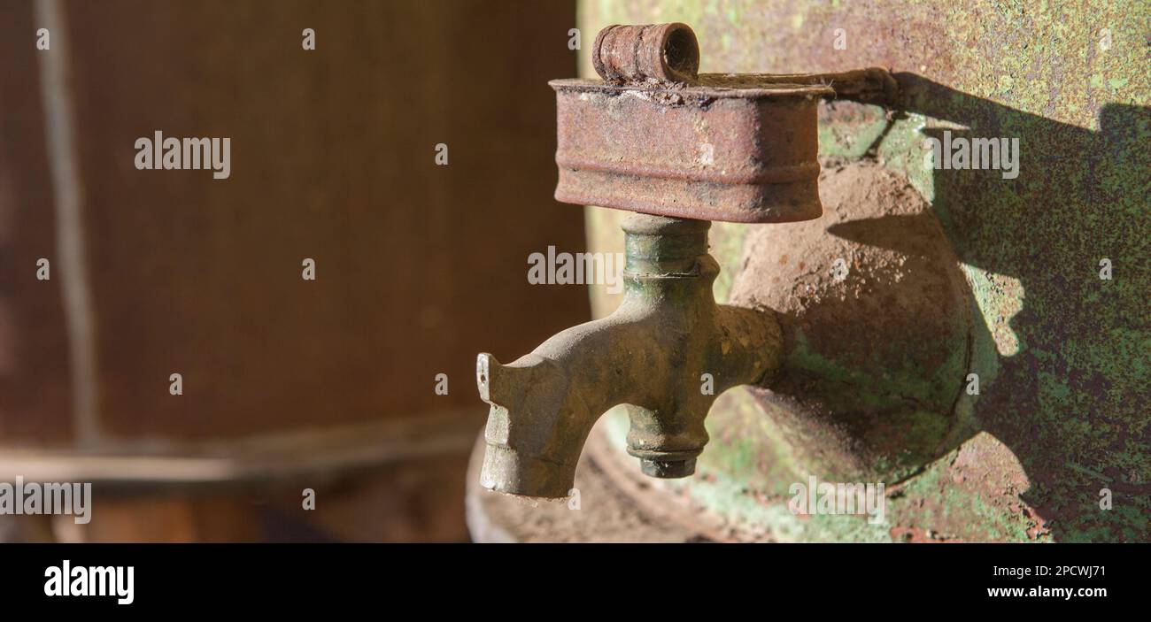 Dettaglio del rubinetto arrugginito dal vecchio tamburo dell'olio d'oliva. Vecchio sfondo fattoria Foto Stock