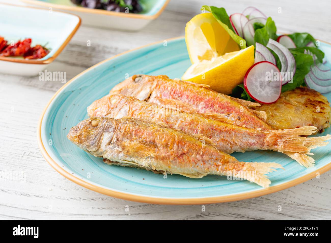 Delizioso triglie alla griglia con guarnire come limone, verdure e cipolle Foto Stock