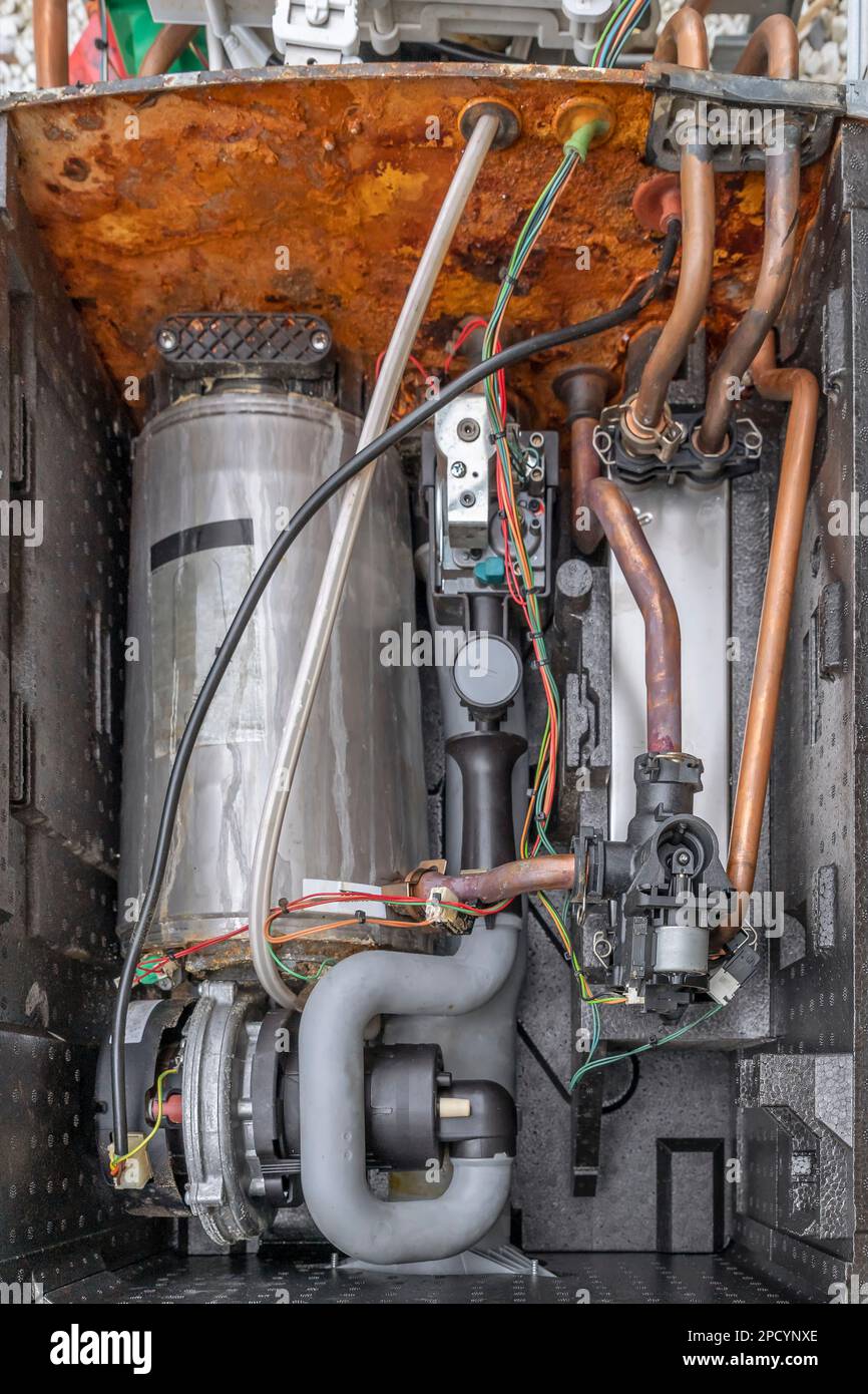 L'interno di una caldaia a condensazione completamente devastata da ruggine e calcare, a causa della durezza dell'acqua Foto Stock