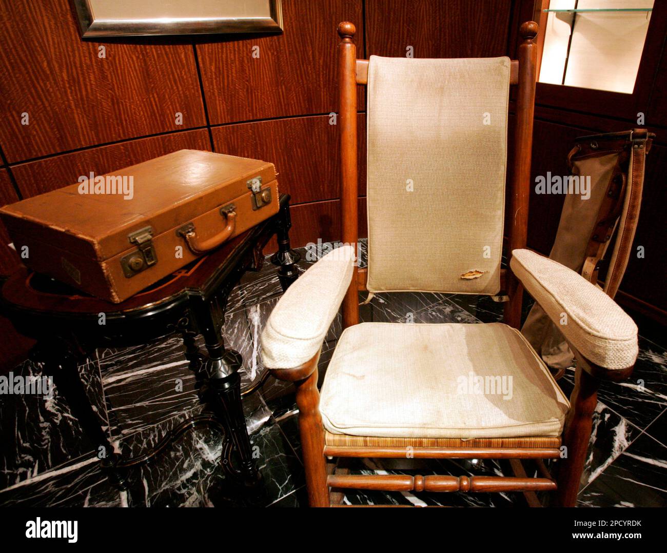 President Back Rocker A brief case, left, rocking chair, center, and a golf bag, back right ...