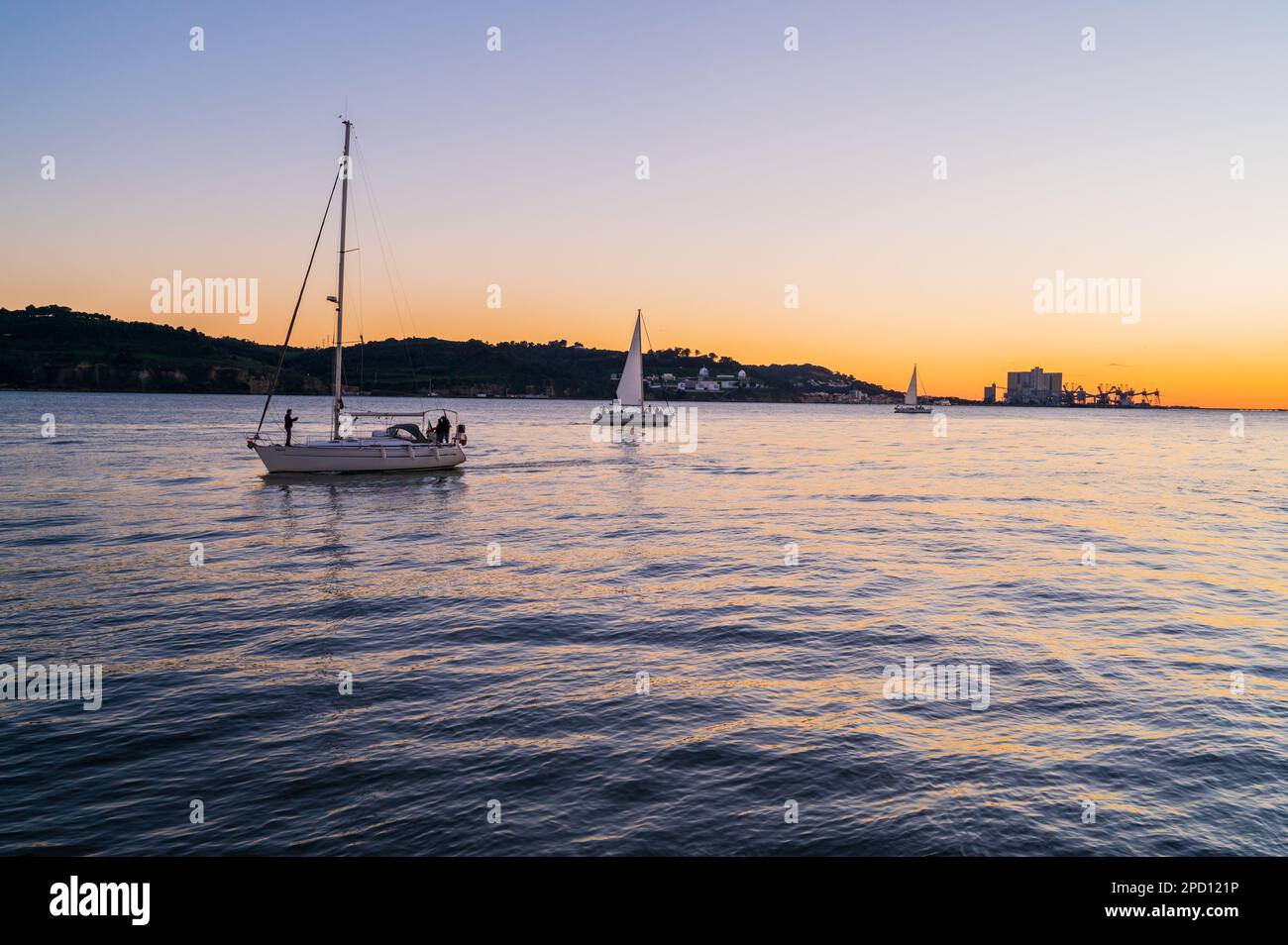 Barche a vela al tramonto sul fiume Tago, Belem, Lisbona, Portogallo Foto Stock