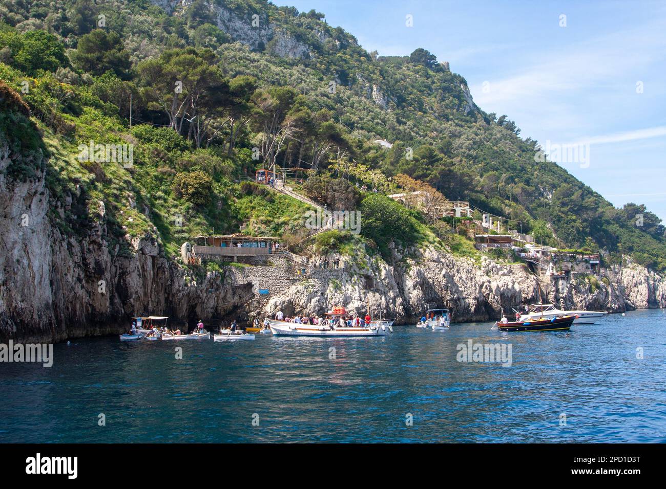 Barche e barche a remi all'ingresso della Grotta Azzurra, Capri, Italia Foto Stock