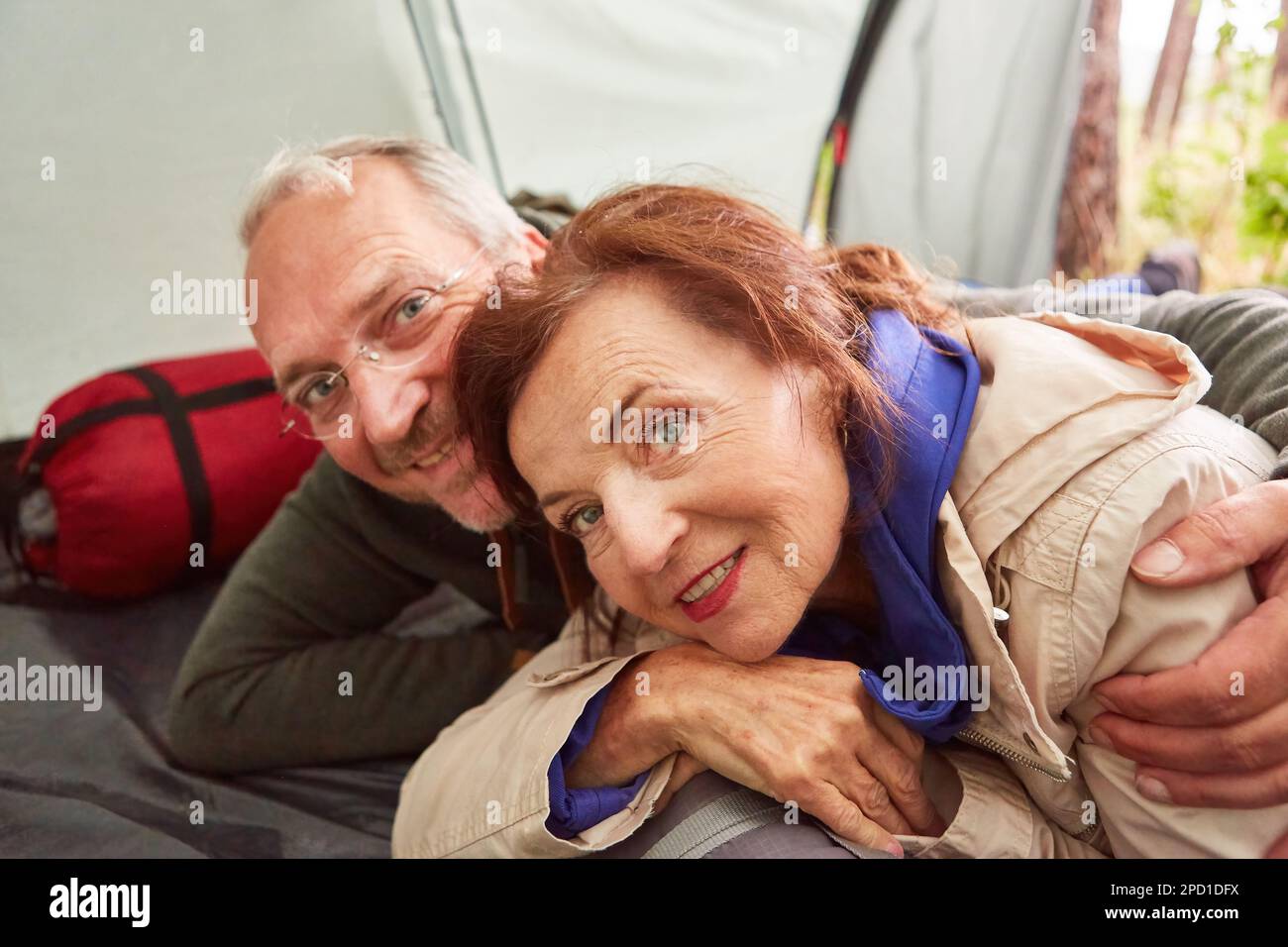 Felice coppia anziana innamorata sdraiata in tenda sul campeggio in natura Foto Stock
