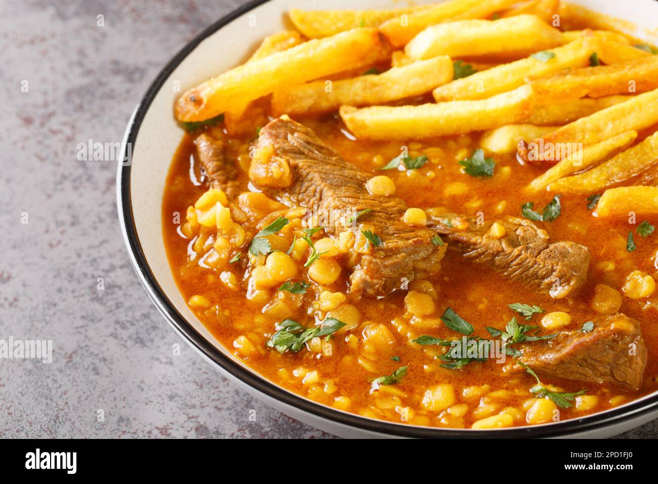 Gheimeh o Qeimeh è uno stufato iraniano composto da montone a dadini o manzo, pomodori, piselli spaccati, cipolla e lime secca, guarniti con pota croccante d'oro Foto Stock