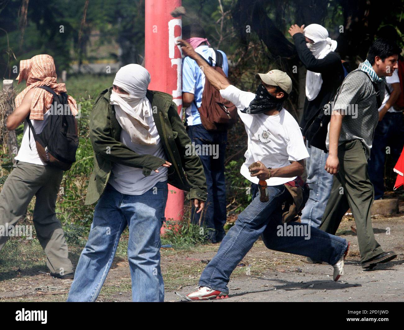 University students throw rocks at riot police during a protest against a fare increase for public transportation in front of the Autonomous National University of Nicaragua (UNAN), in Managua, Nicaragua, Wednesday, May 24, 2006. The street protests have been triggered by the unauthorized fare increase of the equivalent of 18 U.S. cents. (AP Photo/Esteban Felix) Foto Stock