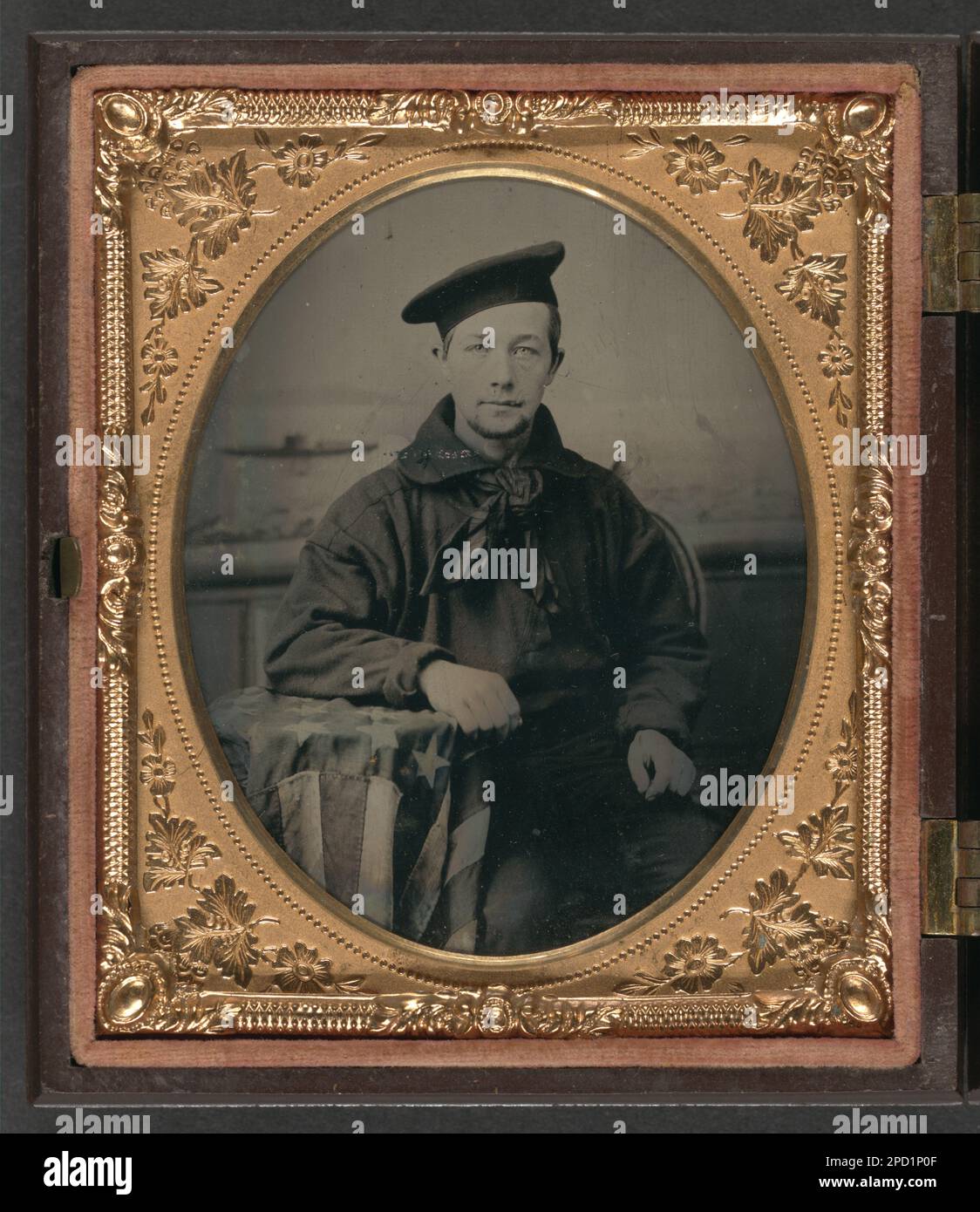 Marinaio non identificato in uniforme Union con un tavolo con bandiera americana drappeggiato di fronte a sfondo dipinto che mostra una scena d'acqua. Liljenquist Family Collection of Civil War Photographs , ha esposto: 'The Last Full Measure : Civil War Photographs from the Liljenquist Family Collection' alla Library of Congress, Washington, D.C, 2011, pp/liljunion. Stati Uniti, Marina, persone, 1860-1870, marinai, Unione, 1860-1870, uniformi militari, Unione, 1860-1870, Backdrops, 1860-1870, Stati Uniti, Storia, Guerra civile, 1861-1865, personale militare, Unione. Foto Stock