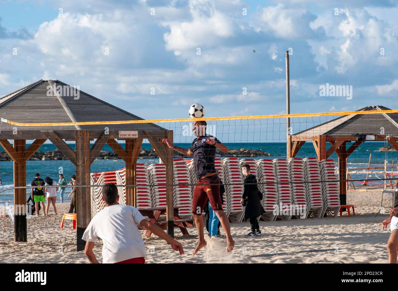 Giovani uomini locali giocano a piedi sul Gordon Beach, Tel Aviv, Israel Footvolley è Beach volley, tranne i giocatori non sono autorizzati ad usare le loro mani A. Foto Stock