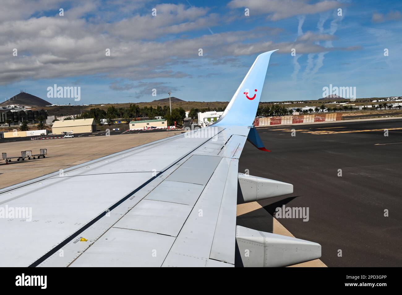 Un'ala di un Boeing 737 TUI noleggiato aeroplano preso in volo che mostra la chiarezza del cielo blu e delle nuvole disperse sotto Foto Stock