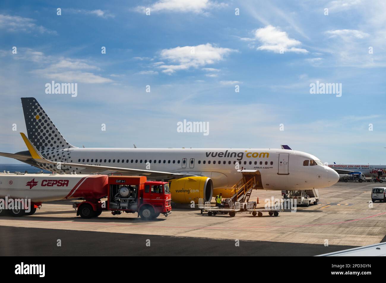 Un aereo di Vueling.com km è stato caricato seduto all'aeroporto di Lanzarote, con una cisterna Cepsa a fianco Foto Stock