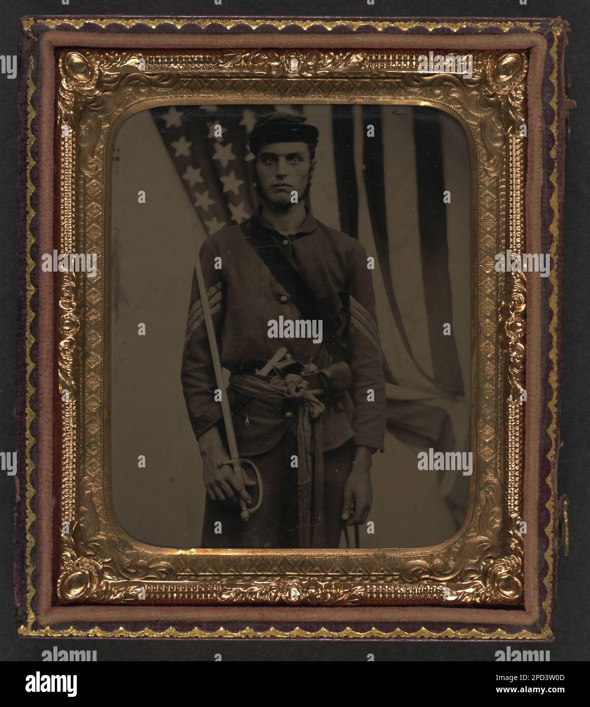 Soldato non identificato in uniforme sergente dell'Unione e sash con la spada, il revolver, la scatola del cappuccio e il coltello dell'ufficiale non commissionato della Model 1840 davanti alla bandiera americana. Liljenquist Family Collection of Civil War Photographs , ha esposto: 'The Last Full Measure : Civil War Photographs from the Liljenquist Family Collection' alla Library of Congress, Washington, D.C, 2011, pp/liljunion. Stati Uniti, Esercito, persone, 1860-1870, soldati, Unione, 1860-1870, uniformi militari, Unione, 1860-1870, Pugnali e spade, 1860-1870, pistole, 1860-1870, coltelli, 1860-1870, backdrops, 1860-1870, Stati Uniti, Storia Foto Stock