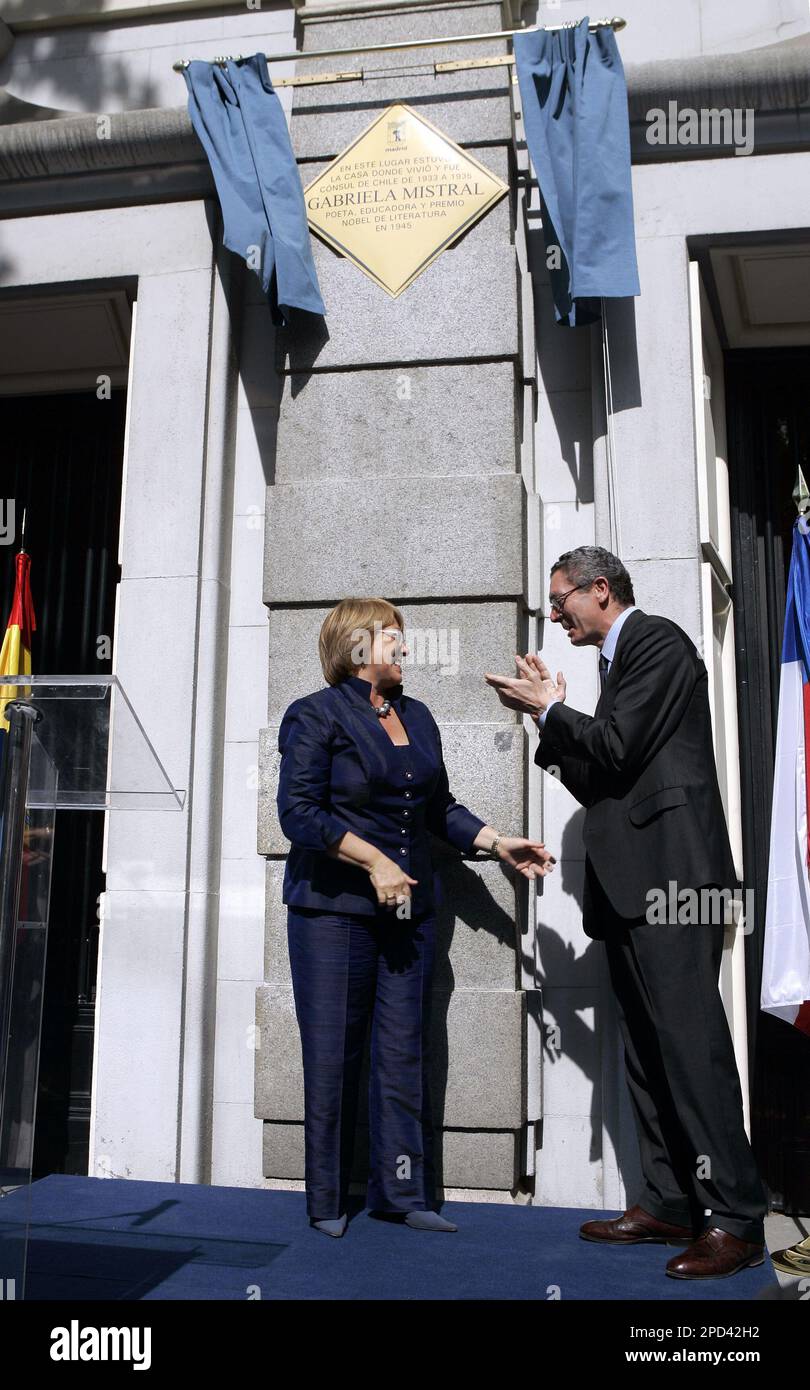 Chile's President Michelle Bachelet, left, is applauded by Madrid's Mayor  Alberto Ruiz Gallardon after she unveiled a commemoration plaque at the  former Chilean consulate, in honour of Chilean poet and 1945 Nobel