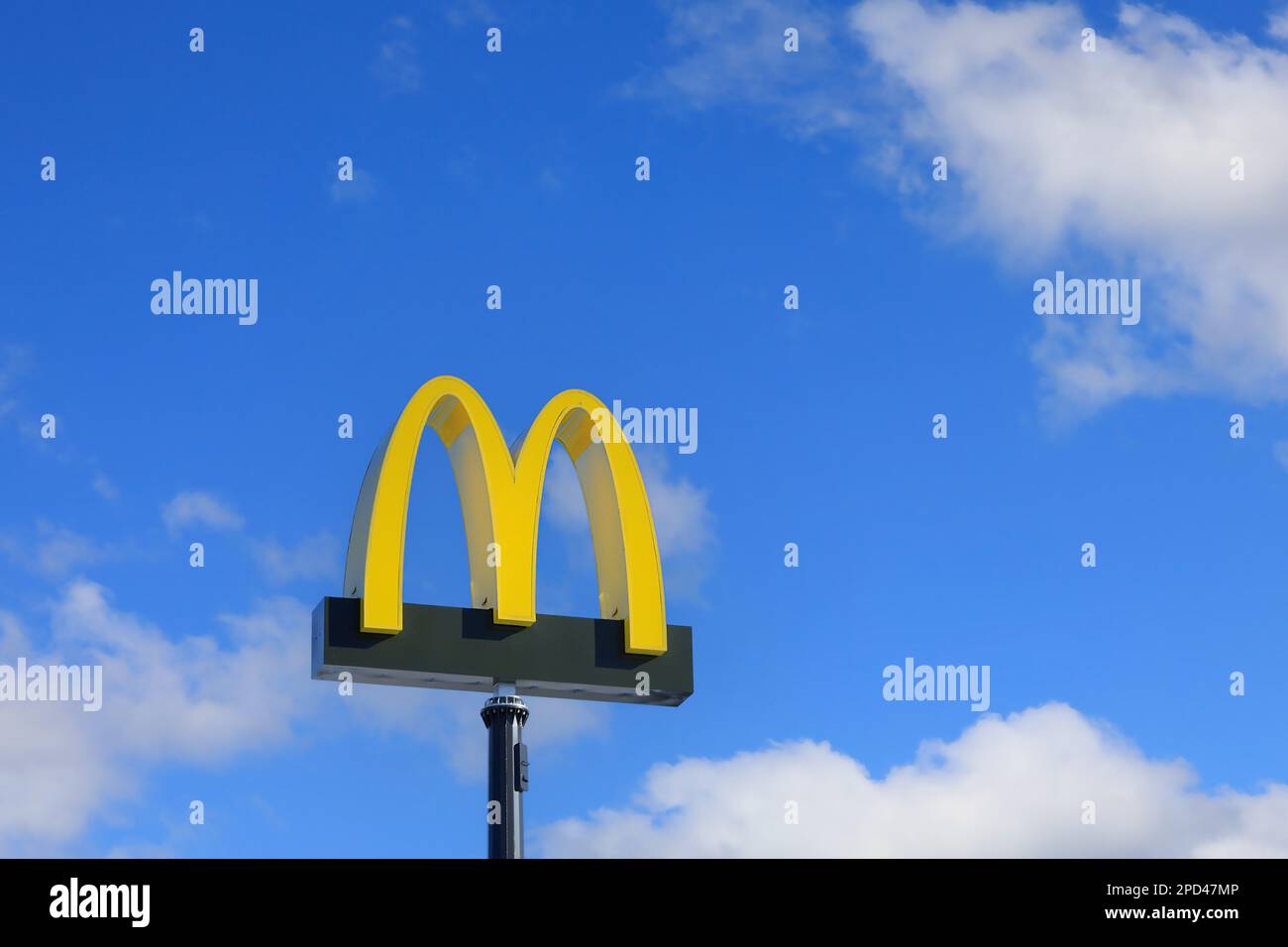 Il logo McDonald's contro il cielo blu e le nuvole bianche del bel tempo al ristorante McDonald's di Salo, Finlandia. Marzo 12, 2023. Foto Stock