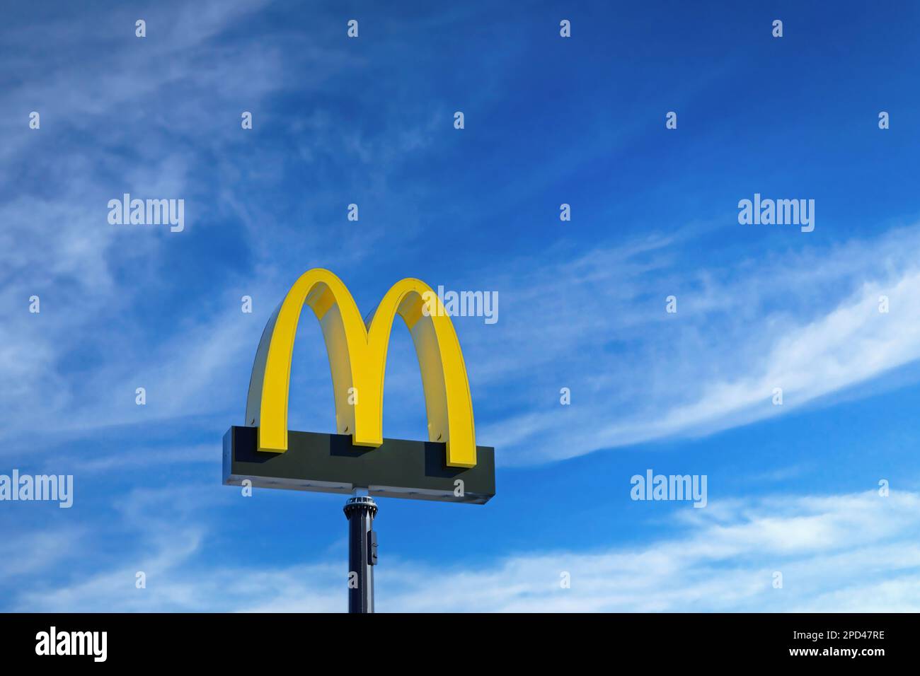 Il logo McDonald's contro il cielo blu e le nuvole bianche del bel tempo al ristorante McDonald's di Salo, Finlandia. Marzo 12, 2023. Foto Stock