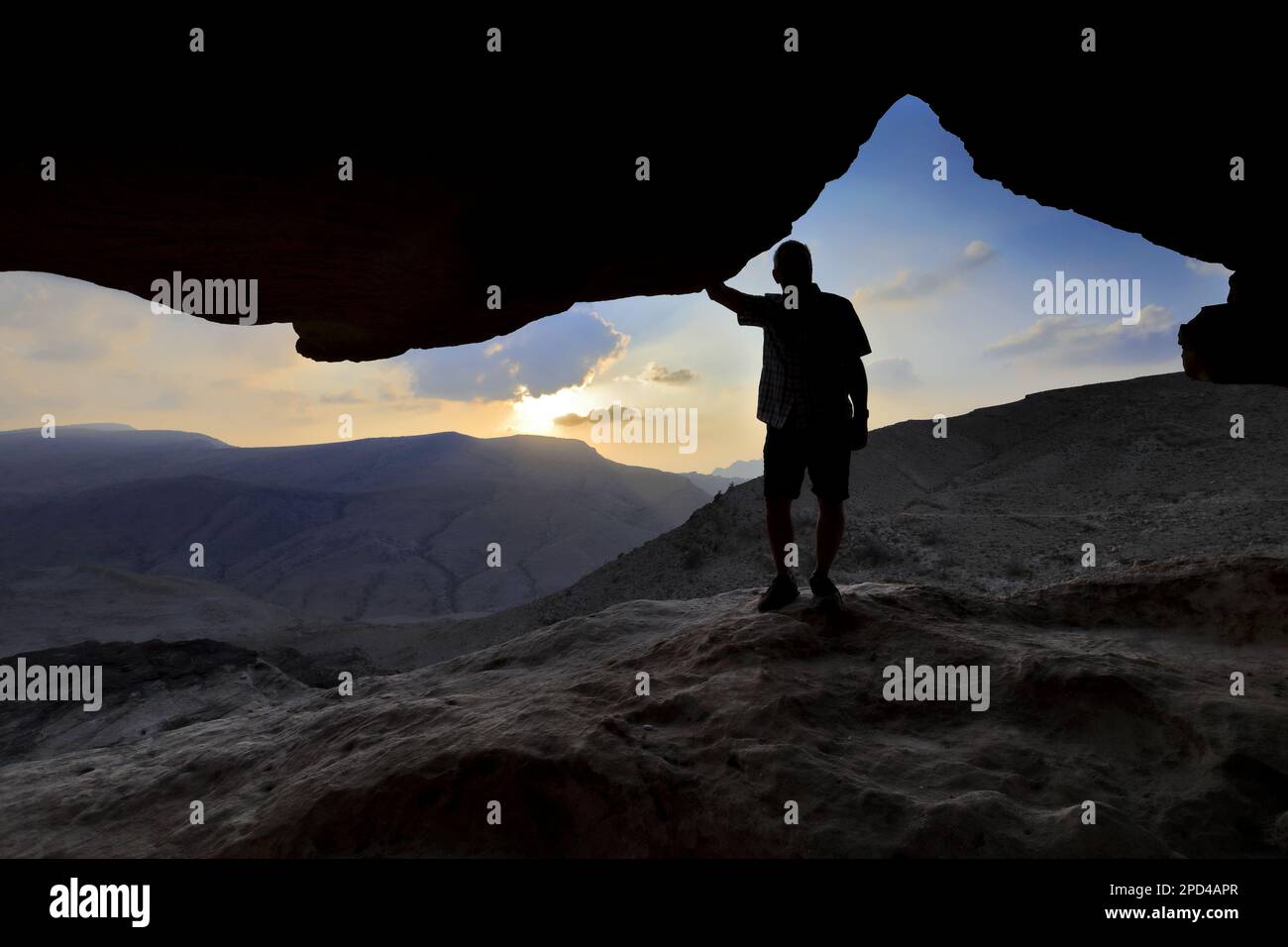 Vista del tramonto attraverso un arco di pietra a Reis al Fied, Wadi Feid, Giordania, Medio Oriente Foto Stock