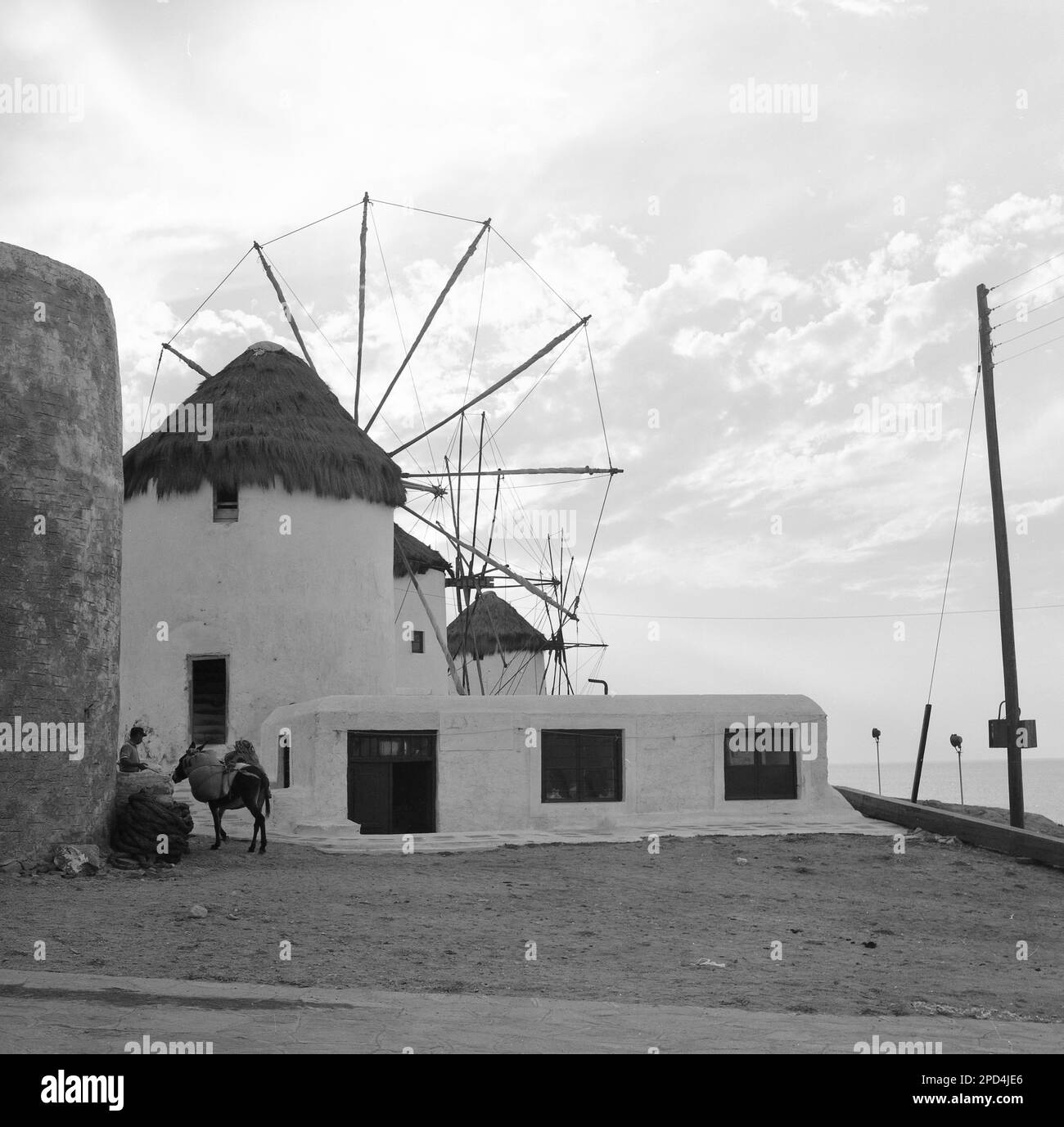 1969, storico, Grecia, mulino a vento, uomo locale con asino caricato Foto Stock