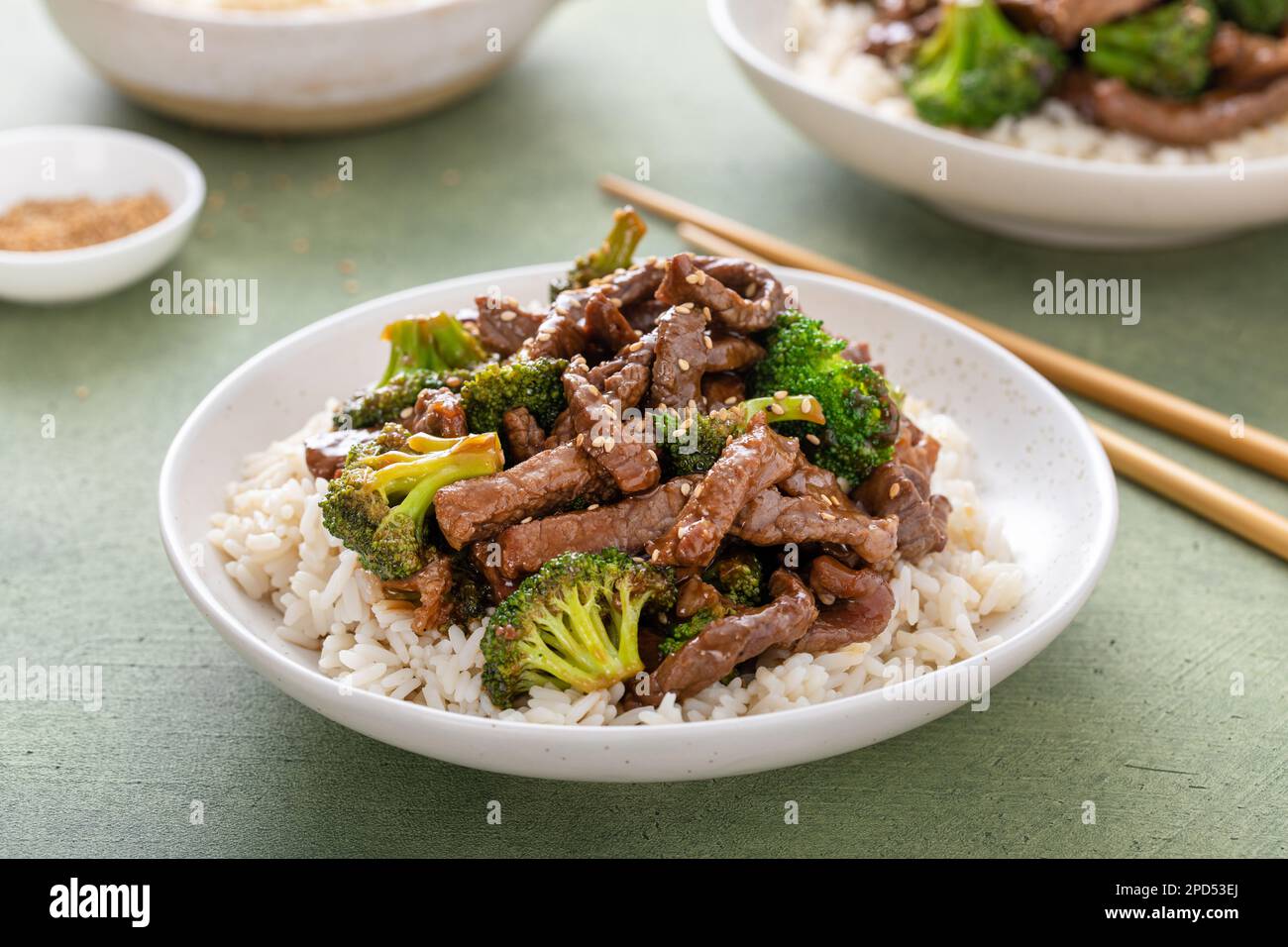 Manzo e broccoli serviti su un piatto di riso su fondo verde Foto Stock
