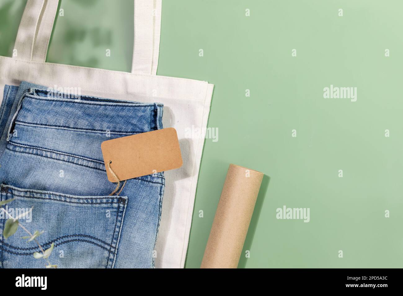 Vita ferma sostenibile con jeans con etichetta vuota, borsa in tessuto e carta da imballaggio. Negozio di abbigliamento ecologico. Negozio di abbigliamento casual, shopping, s Foto Stock