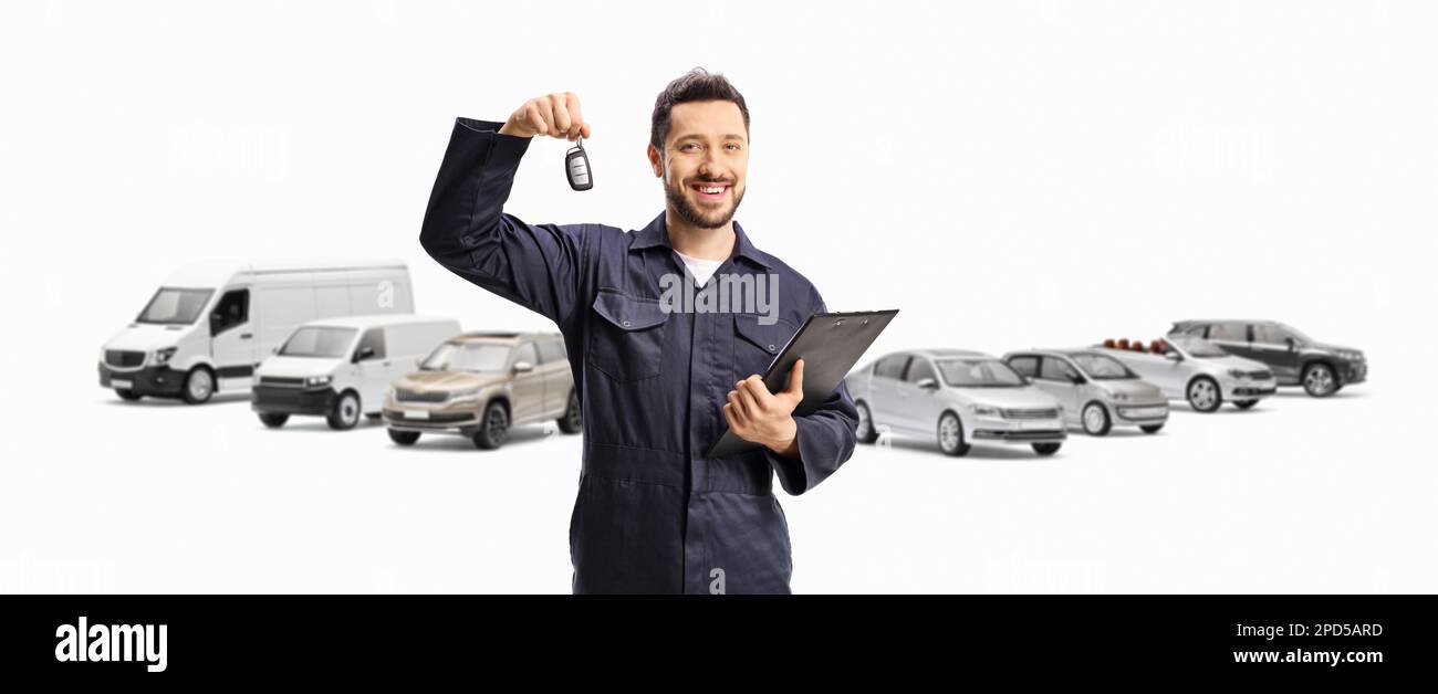 Meccanico che tiene la chiave dell'auto di fronte a diversi veicoli parcheggiati isolati su sfondo bianco Foto Stock