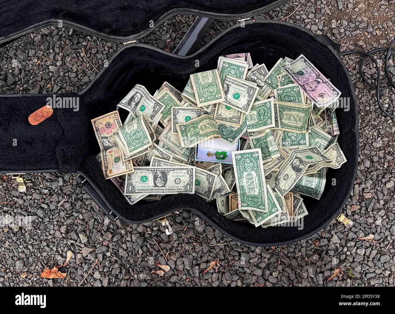 Custodia per chitarra Street performer piena di banconote in dollari Foto Stock