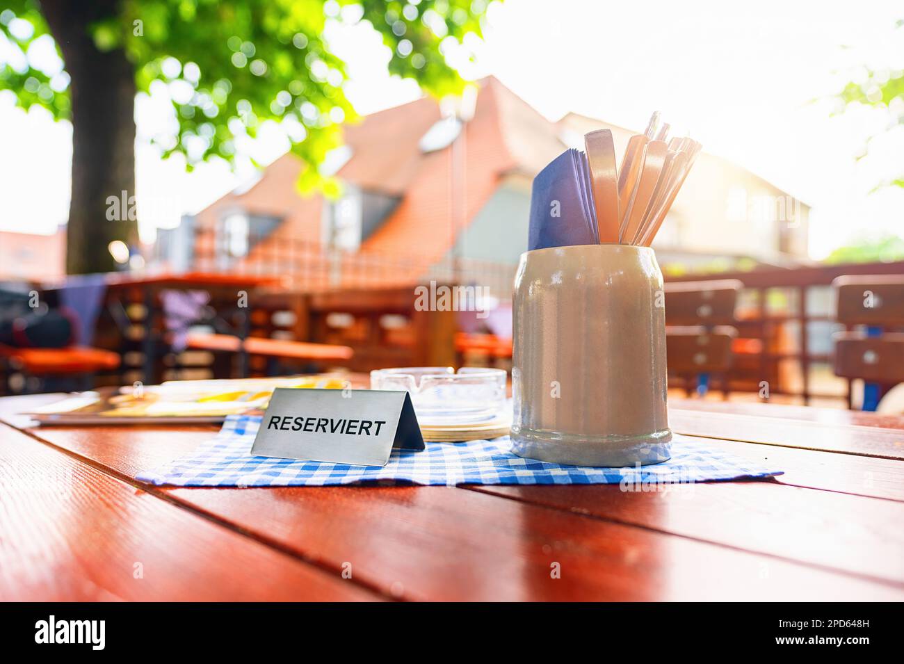 tavolo tedesco birreria all'aperto con cartello da tavolo riservato con posti in estate Foto Stock