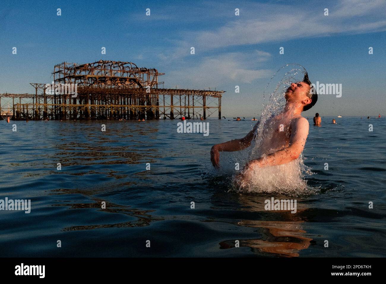 Gente che gode la bassa marea vicino al Molo occidentale sulla spiaggia di Brighton - Brighton & Hove, Sussex orientale, Regno Unito Foto Stock