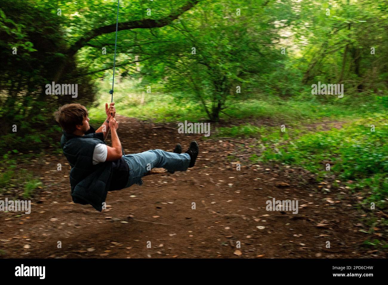 Giovane uomo su una corda swing a Stanmer Park, alla periferia di Brighton & Hove, East Sussex, Regno Unito Foto Stock