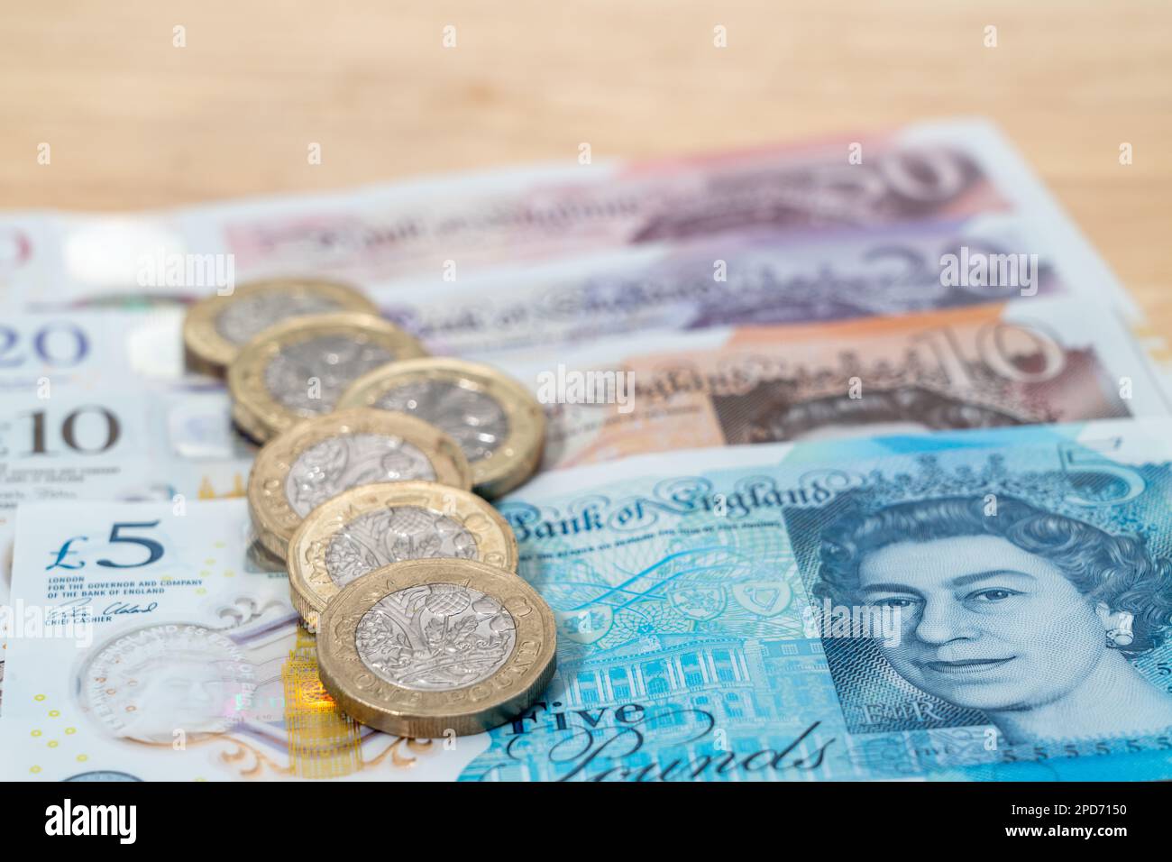 Primo piano di banconote britanniche e monete da una libbra Foto Stock