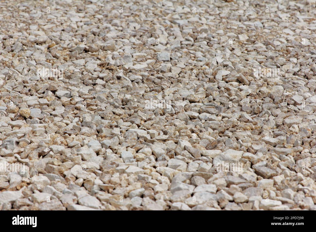 Ghiaia di grandi frazioni pietra frantumata costruzione aggregata struttura in pietra. La pietra schiacciata si trova a terra. Pietra di rottura. Struttura in ghiaia di granito Foto Stock