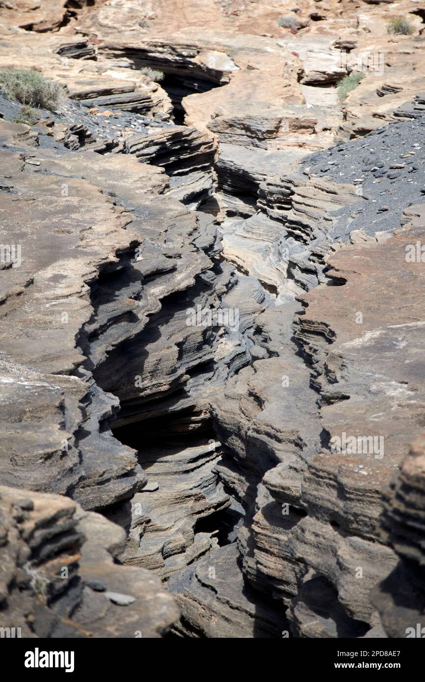 Strati di roccia vulcanica in crepacci consumati dall'erosione di las grietas ladera del volcan Lanzarote, Isole Canarie, Spagna Foto Stock