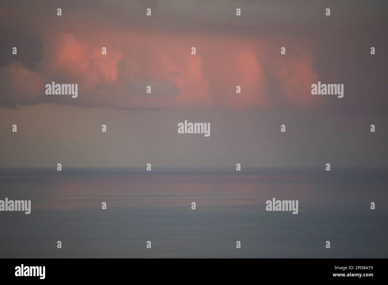 Pioggia evidenziata dalla luce rossa dal tramonto sul mare Lanzarote, Isole Canarie, Spagna Foto Stock