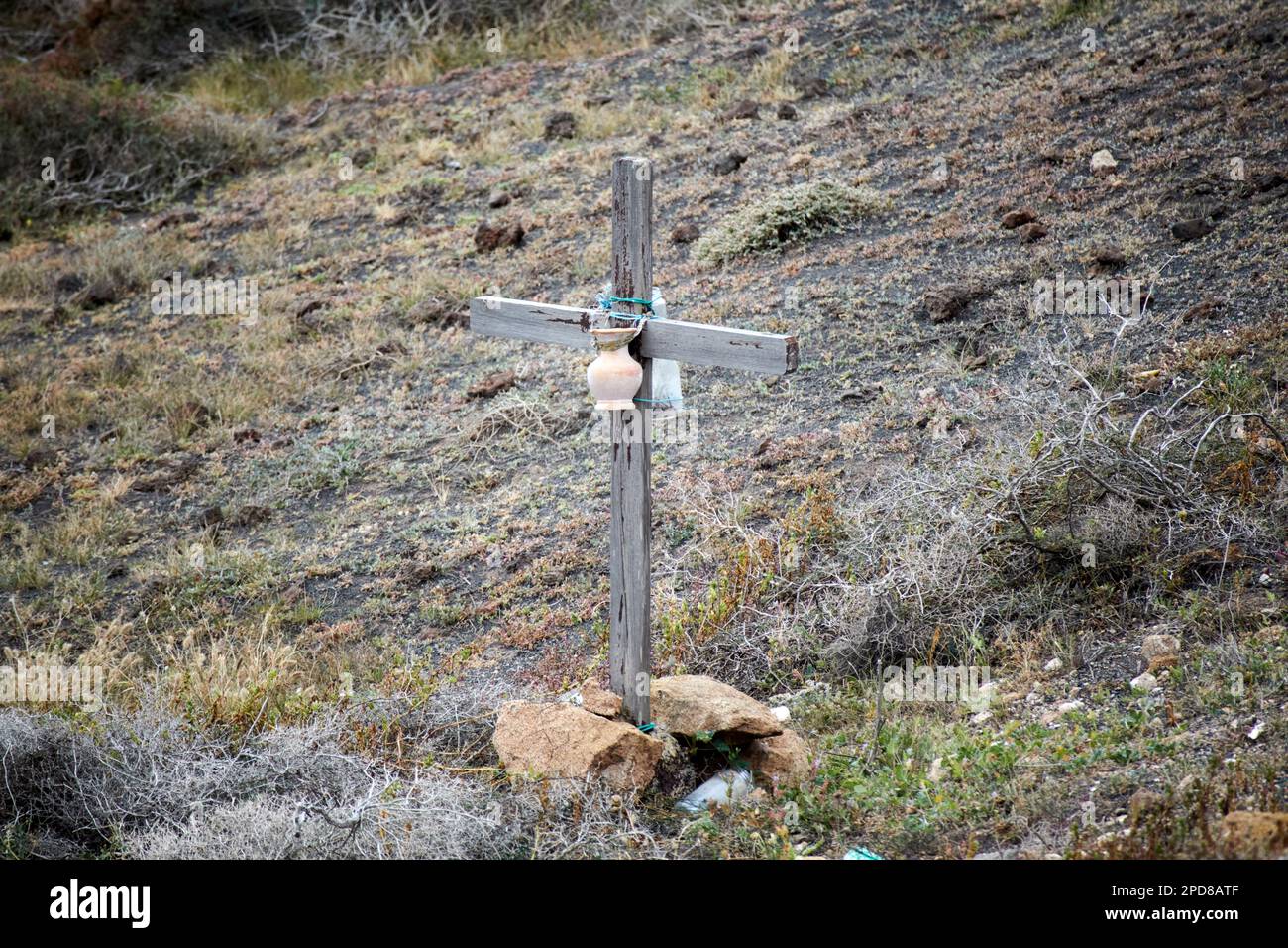 Croce di legno e offerte sul lato della strada in una zona rurale di montagna dove qualcuno è morto a causa di un incidente di auto Lanzarote, Canary Isla Foto Stock